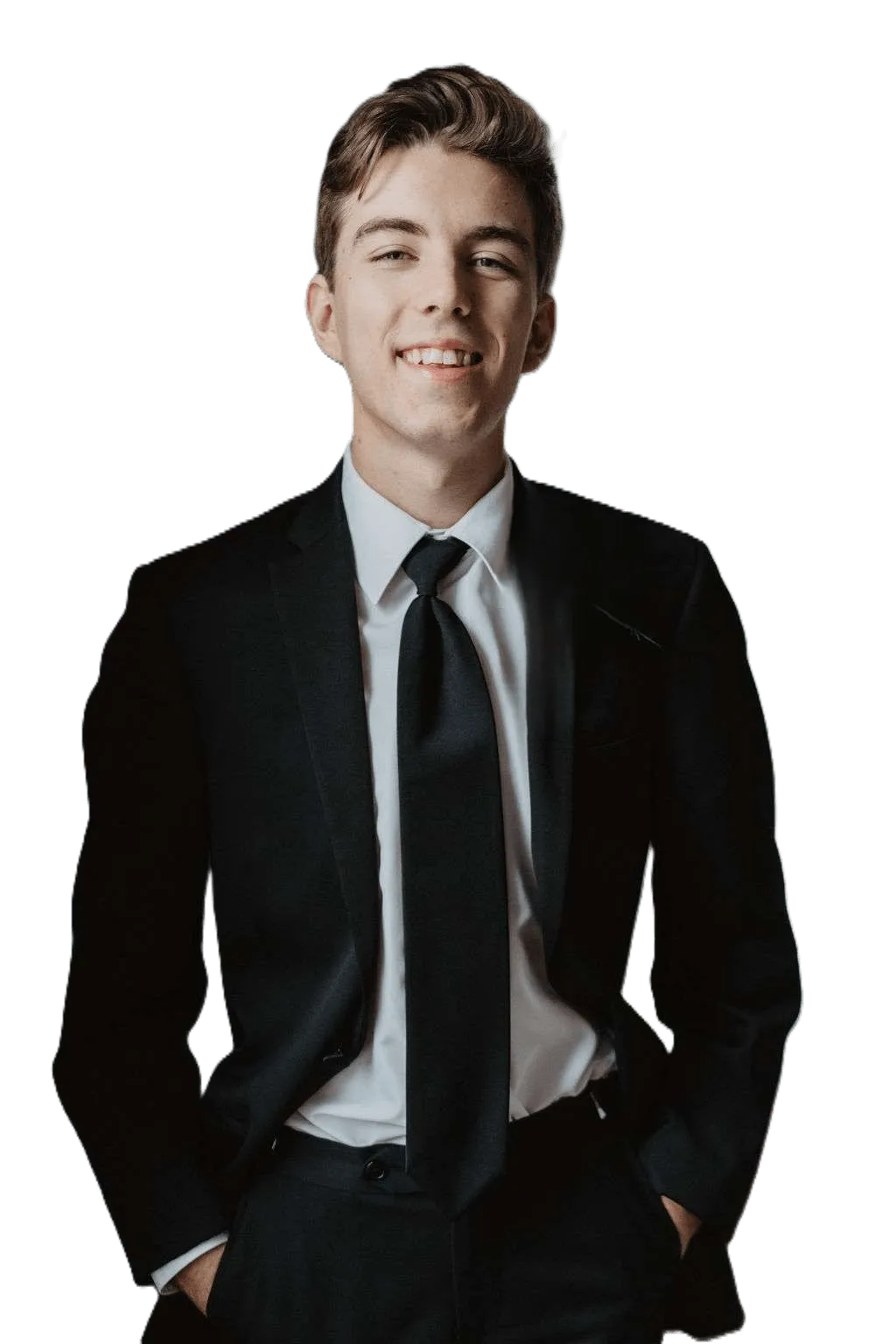 Xander Riddle in a black suit, hands in pockets, smiling